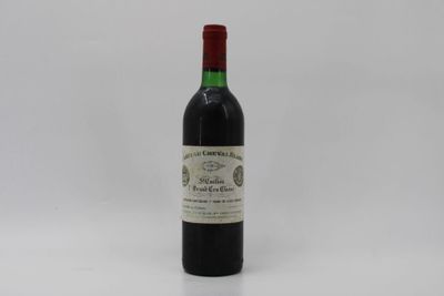 a bottle of red wine sitting on top of a white table
