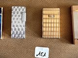 four different types of lighters are lined up on a brown surface