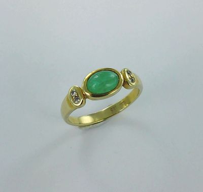 une bague en or sertie d'une pierre verte et de deux diamants