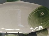 a fish shaped dish with a clock on the side