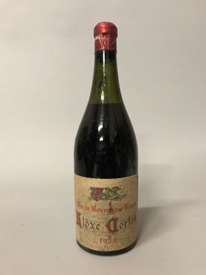 une vieille bouteille de vin posée sur une table blanche