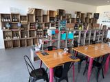 des tables et des chaises dans une pièce dont les étagères sont remplies de bouteilles de vin