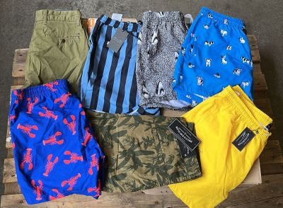 plusieurs paires de shorts pour homme posées sur une caisse en bois