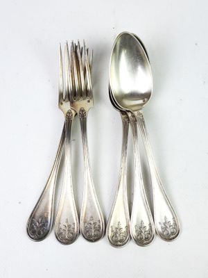 quatre cuillères en argent et une fourchette sur une table blanche