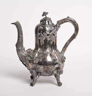 une théière ancienne en argent surmontée d'un oiseau