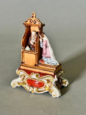 a miniature figurine of a man and a woman sitting in a chair