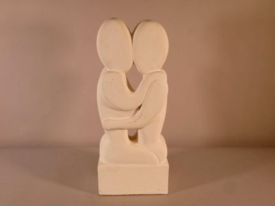 une sculpture blanche représentant deux personnes qui s'étreignent