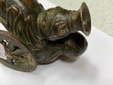 a bronze figurine of a man sitting on a cart