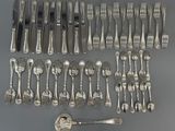 de nombreuses fourchettes et cuillères disposées sur la table