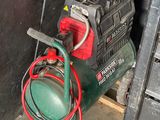 une photo d'un compresseur d'air vert dans un garage