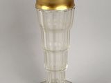 a glass vase with a gold rim sitting on a table