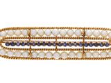 un gros plan sur une barrette ornée de perles blanches et bleues