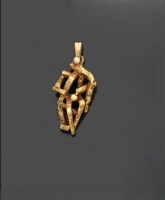 gros plan d'un pendentif en or sur une surface noire