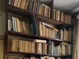 a book shelf with many books on it in a living room