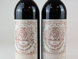 deux bouteilles de vin rouge posées l'une à côté de l'autre sur une surface blanche