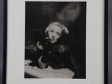 photographie en noir et blanc d'une femme fumant une cigarette, dans un cadre noir