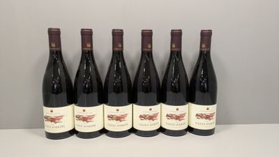 six bouteilles de vin rouge alignées sur une table