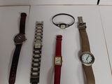 several watches and bracelets are displayed on a white surface