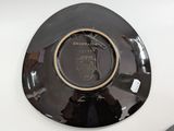 a black plate with a horse on it on a table