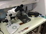 un microscope posé sur une table dans une pièce encombrée