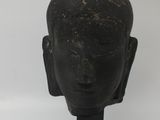 statue of a head of a buddha on a wooden base