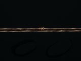 un bracelet en or et une paire de boucles d'oreilles sur fond noir