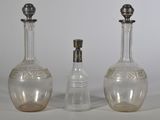 three glass bottles sitting next to each other on a table