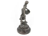 bronze statue of a woman holding a basket on a pedestal