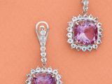 une paire de boucles d'oreilles en saphir rose et diamants sur fond orange
