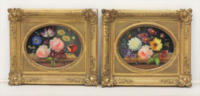une paire de tableaux représentant des fleurs, dans un cadre doré, accrochés à un mur blanc