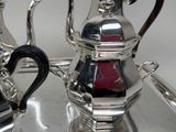 two silver teapots sitting on a silver tray