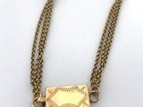 a close up of a baseball necklace on a white surface