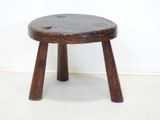 a small wooden stool sitting on a white floor