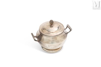 une théière ancienne en argent posée sur une surface blanche, munie d'une anse