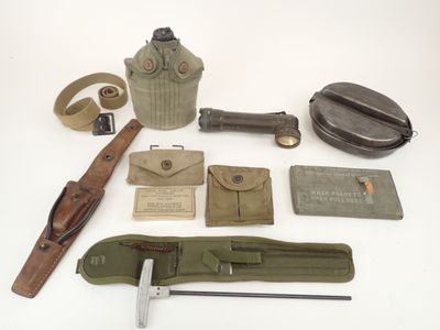 an assortment of military items including a gas can, knife, and other items