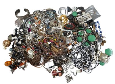 a pile of assorted jewelry on a white surface