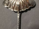 a silver spoon with a flower on it on a table