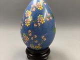 a close up of a blue egg with flowers on it