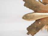 a close up of a gold object on a white surface