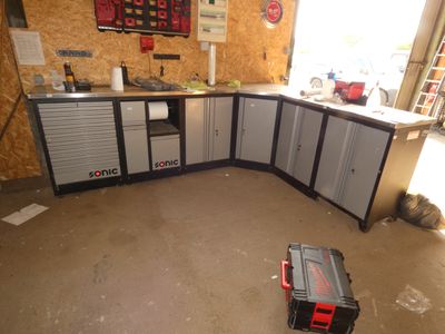 une photo d'un garage avec une boîte à outils posée au milieu du sol