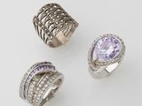 trois bagues et une bague sertie de diamants sur un fond blanc