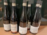 six bouteilles de vin sont alignées sur une table