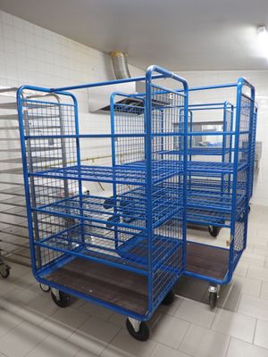 many blue carts in a room with white tile flooring