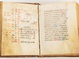 an old open book with writing on it sitting on top of a table