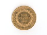a gold coin on a white surface with a white background