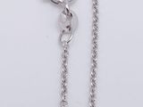 a close up of a pair of silver chains on a white surface