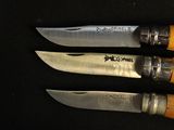 three knives that are sitting on a black surface