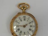 a gold pocket watch with roman numerals on it