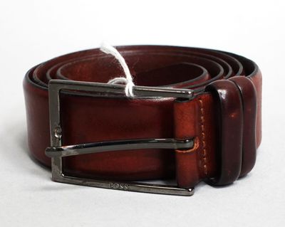 ceinture en cuir marron avec une boucle argentée sur un fond blanc