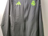 une veste grise suspendue à un cintre, sur lequel figure un logo vert
